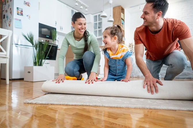 A family unrolls a rug