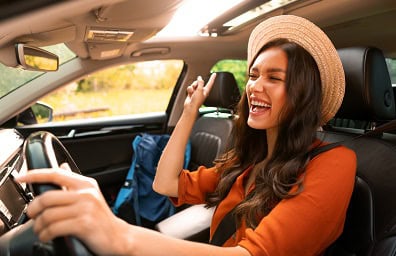 Woman drives her car in the sunshine
