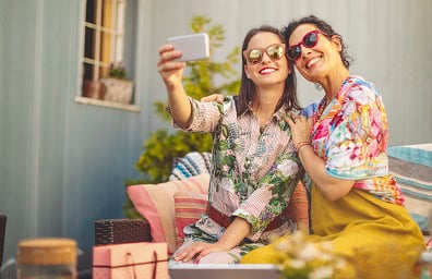 A woman takes a selfie of her and a friend