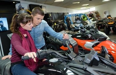 A young couple shops for ATV in shop