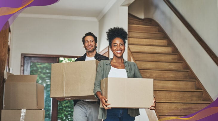 Happy couple moving boxes into their new home.