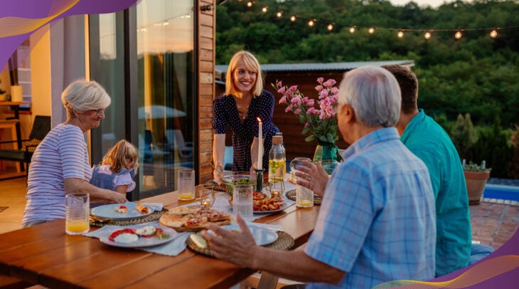 Family eating dinner in backyard during early evening.