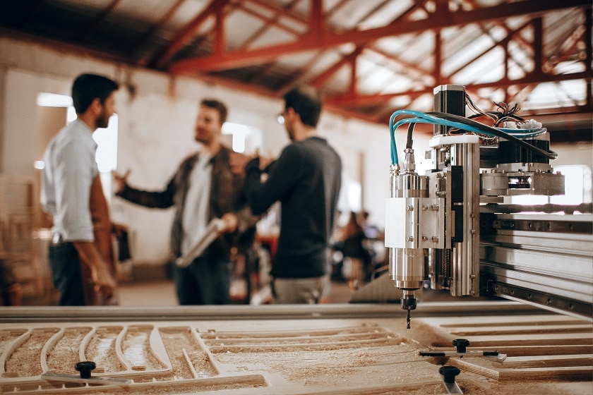 Three men discuss business in a textile factory