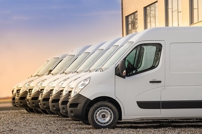 Fleet of white business vans parked on desert lot