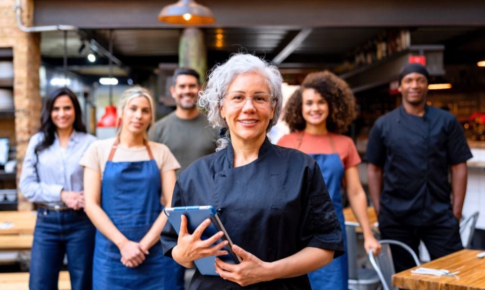 A business owner poses with her staff.