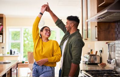 A couple dancing in their kitchen.