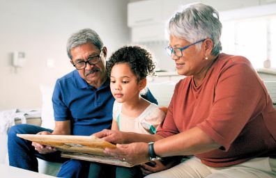 A grandmother and grandfather read a story to their grandchild.