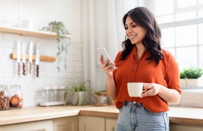 A woman checks her online banking balance on her mobile phone.
