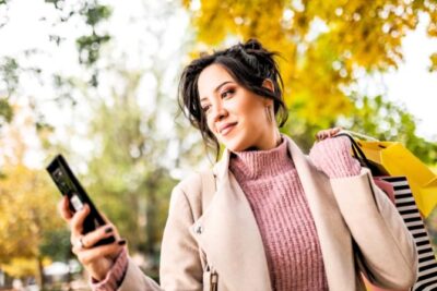 A young woman checks an alert on her phone.