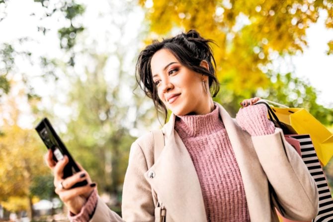 A young woman checks an alert on her phone.