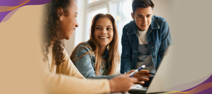 Middle school students smiling and working together in class.