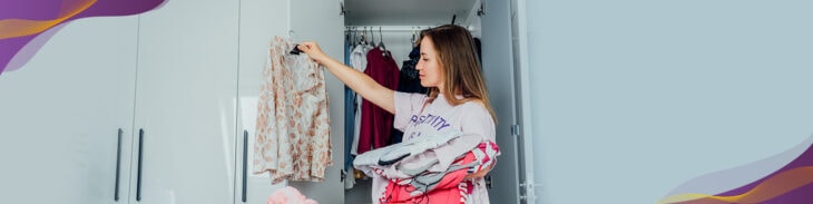 Woman cleaning out closet and looking through clothes to donate.