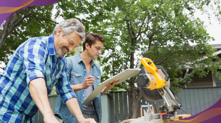 Father and son working on a home improvement project in the backyard with handsaw.