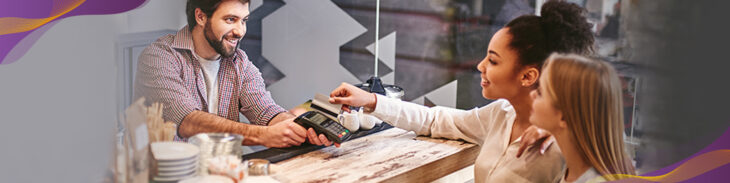 Shoppers paying for purchase at a bakery with a credit card.