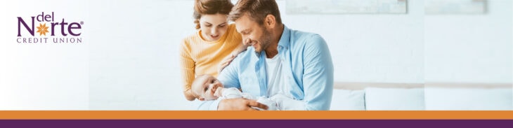 New mom and dad holding infant baby smiling