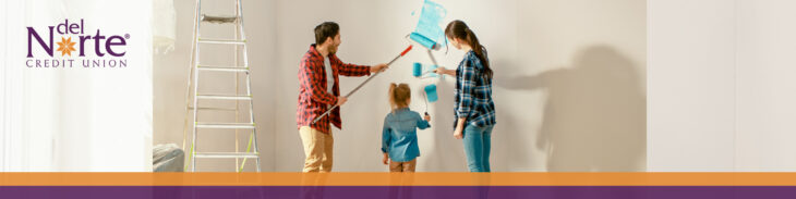 Mom, dad, and daughter painting a wall at home together.