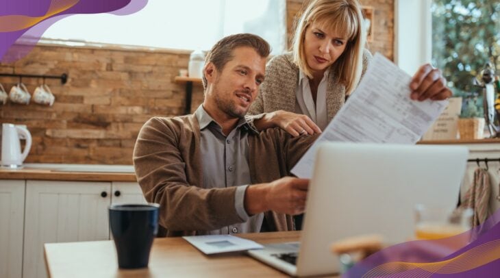 Man and woman looking at utility bill at home.