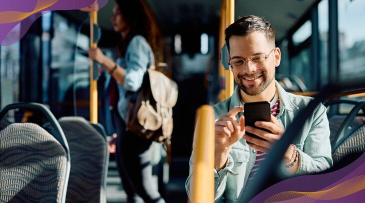 Young man on public transportation bus looking at smartphone.