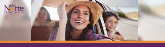 Happy woman smiling and leaning out of car window.