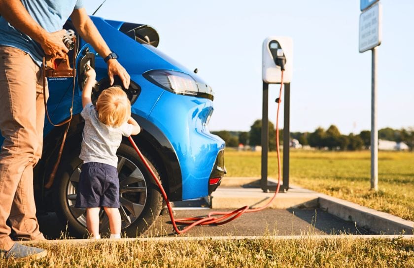 A father and son charge their electric vehicle.
