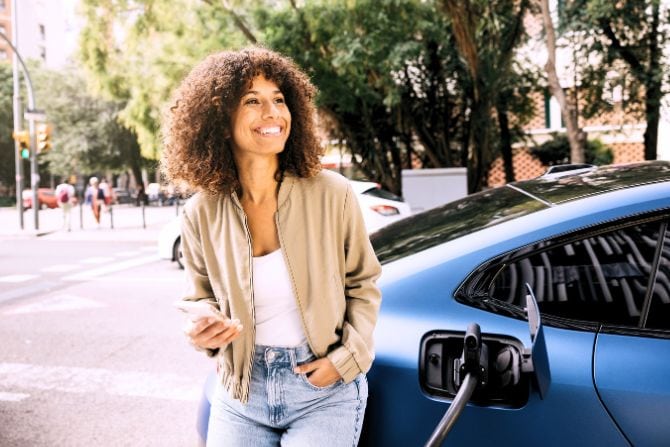 A woman charges her electric vehicle.