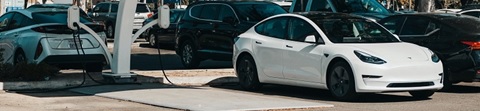 An electric vehicle recharges in a parking lot