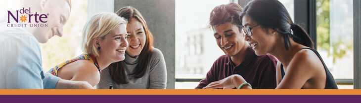 Happy smiling college students sitting at table with large window behind them.