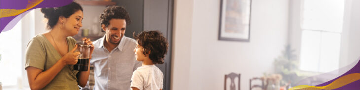 Mom and dad preparing coffee with young child in the kitchen.