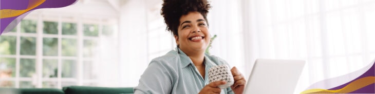 Happy woman drinking coffee working from home.