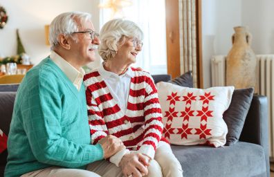 Una pareja de ancianos está sentada junta en su casa.