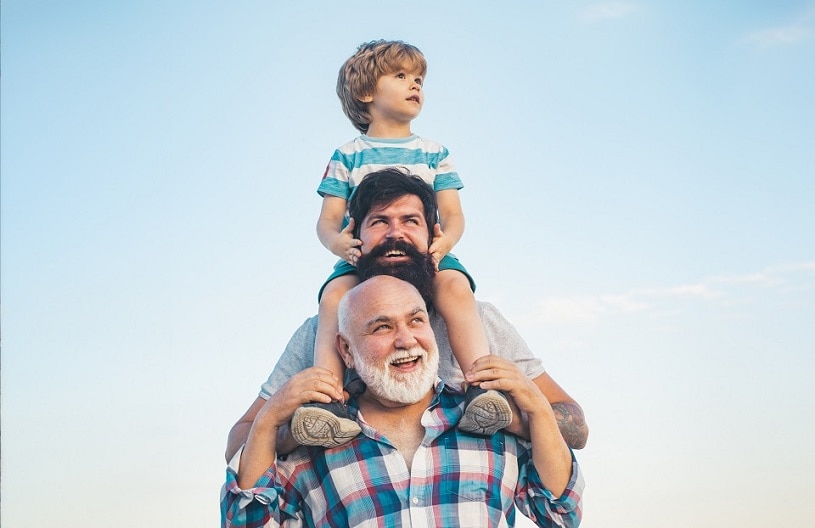 Photo of three generations of men, boy, middle aged man and grandfather standing vertically