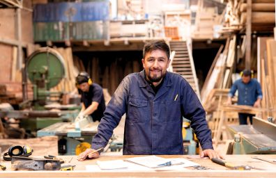 A blue collar worker stands at his work table.