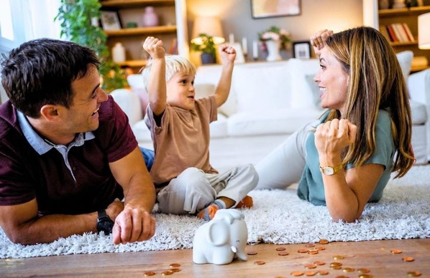 Mamá y papá le enseñan al niño cómo ahorrar dinero.