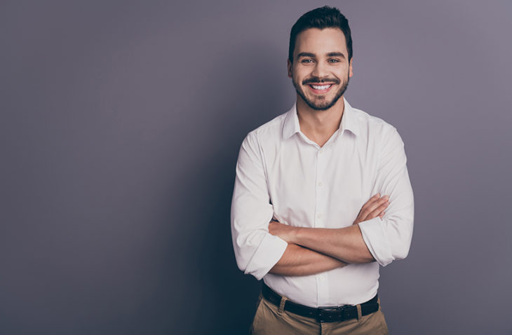 Professional man smiles with arms crossed