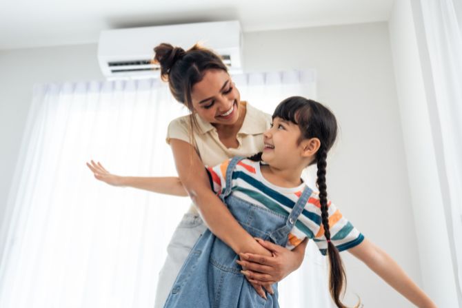 A mom a daughter enjoy their air conditioning during the summer.