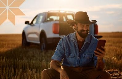 Farmer looks at his phone in the field