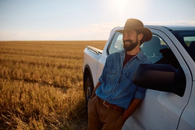 A man leans against his truck.