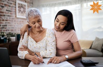 A daughter helps her mom fill out paperwork.
