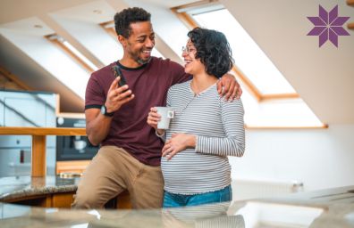 Mom and Dad look at their mobile phone.