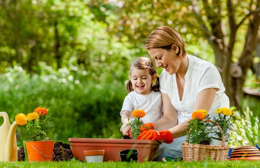 A mom and her daughter plant flowers in the spring.