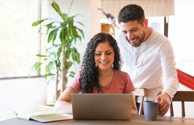 A couple compare offers on their laptop.