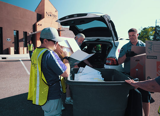 Two volunteers help unload documents to be shredded during DNCU Shred days