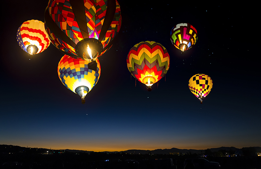 Hot air balloons ascend at night time in Rio Rancho New Mexico