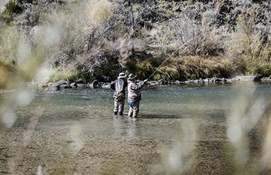 Two friends fly fish outdoors in New Mexico