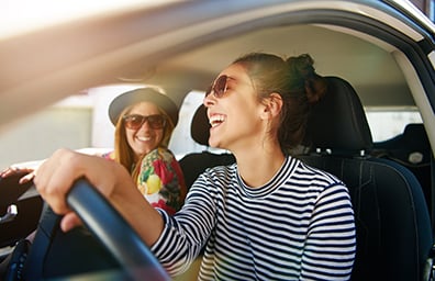 Two young women smiling in car