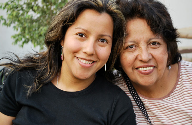 Smiling Hispanic mother and daughter