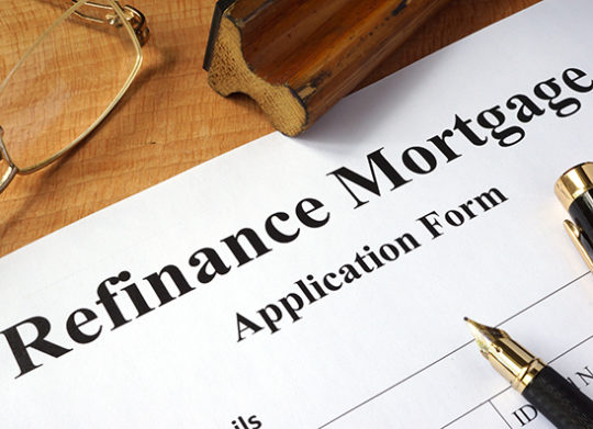 Mortgage refinance application document with pen resting on top