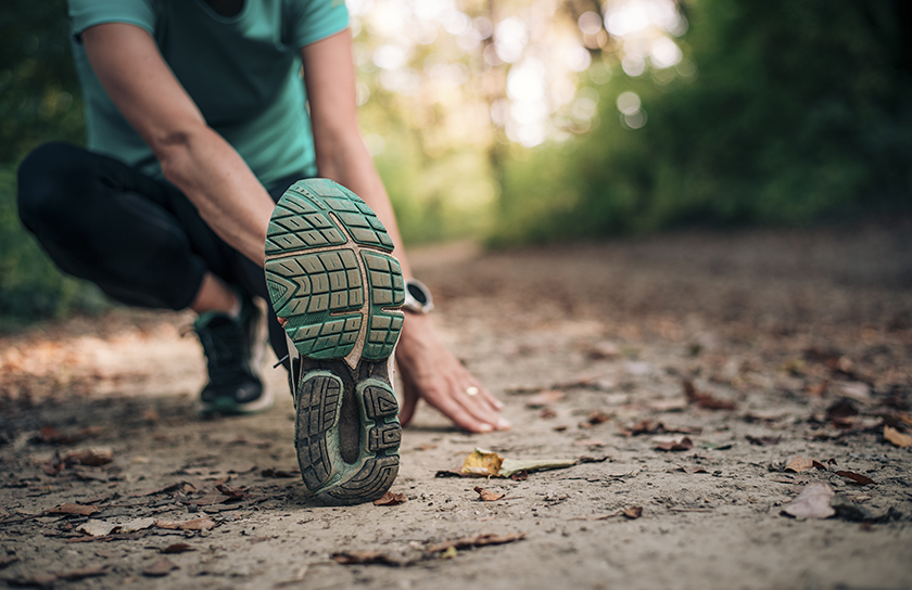 Woman stretching before going on a jog outdoors on trail